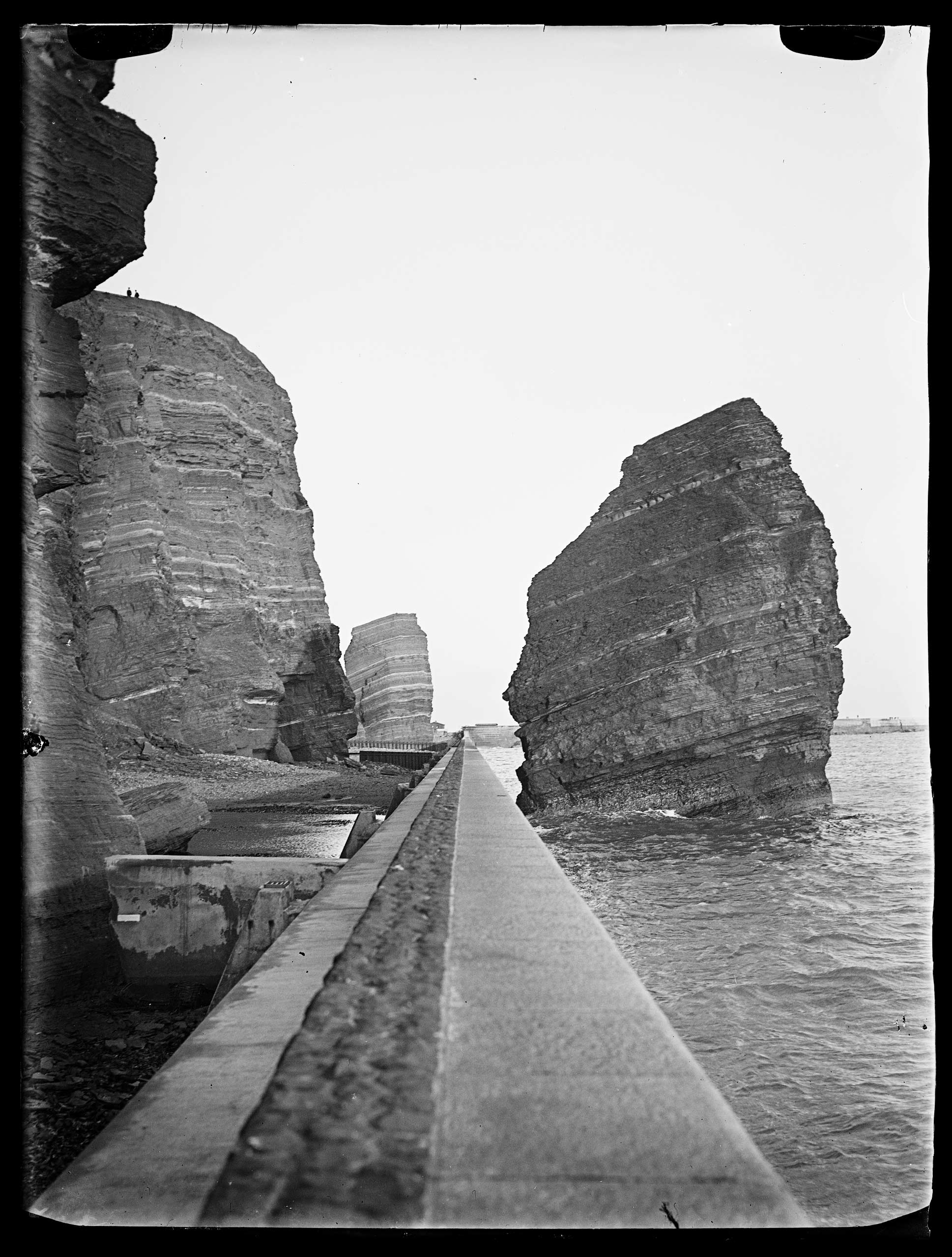 Helgoland 1930, Hafenmauer mit Nonne und Mönch bei Sonnenuntergang